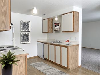 Our apartments offer a kitchen with white appliances and wood cabinets